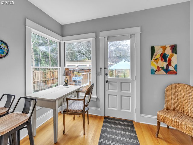 doorway featuring light wood-style floors, a healthy amount of sunlight, and baseboards