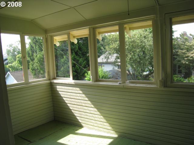 unfurnished sunroom featuring vaulted ceiling