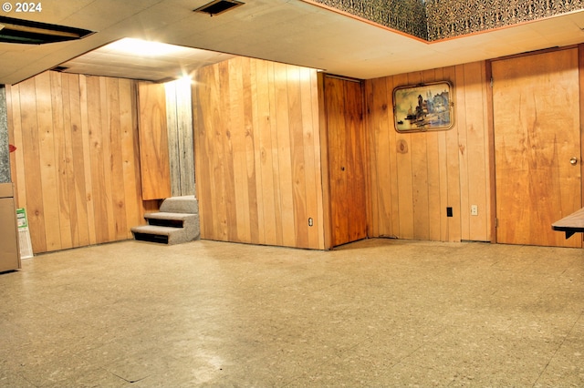 basement featuring wooden walls