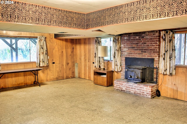 interior space featuring a wood stove and wood walls