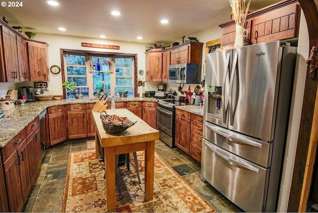 kitchen with light stone countertops and appliances with stainless steel finishes