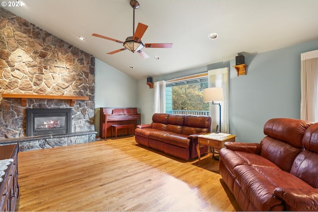 living room with recessed lighting, a ceiling fan, vaulted ceiling, a stone fireplace, and wood finished floors