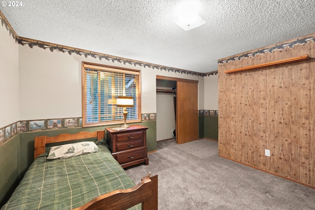 carpeted bedroom with a textured ceiling and a closet