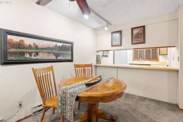 carpeted dining area featuring a textured ceiling, rail lighting, ceiling fan, and a baseboard heating unit