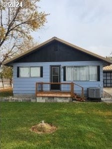 back of property featuring cooling unit, a yard, and a deck