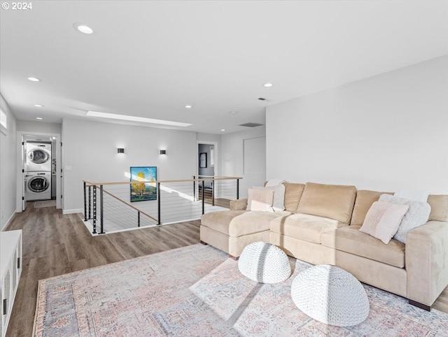 living room featuring light wood-type flooring and stacked washer / dryer