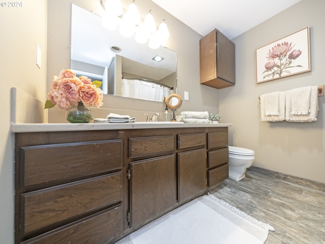 bathroom featuring hardwood / wood-style flooring, vanity, and toilet