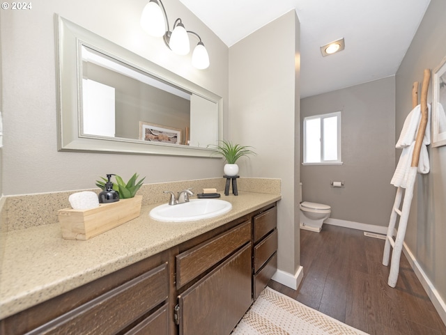 bathroom featuring hardwood / wood-style flooring, vanity, and toilet