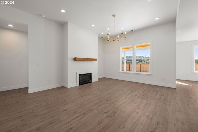 unfurnished living room featuring hardwood / wood-style flooring and a notable chandelier