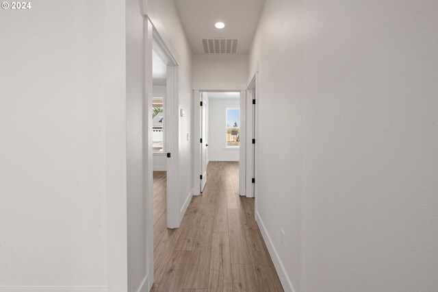 corridor with light hardwood / wood-style flooring