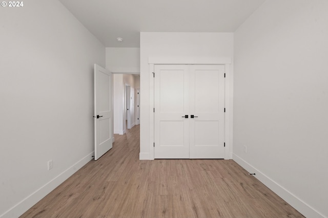 unfurnished bedroom featuring a closet and light hardwood / wood-style floors