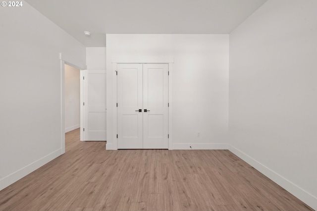 unfurnished bedroom featuring light wood-type flooring and a closet