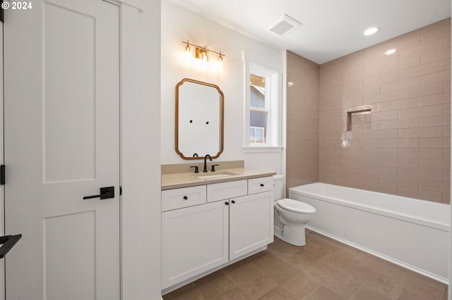 full bathroom with tiled shower / bath, vanity, and toilet