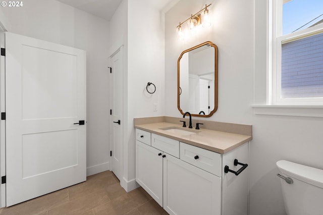 bathroom with tile patterned flooring, vanity, and toilet