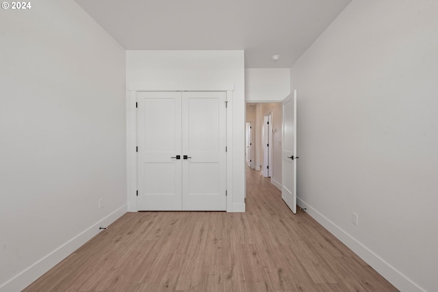 unfurnished bedroom with light hardwood / wood-style flooring and a closet