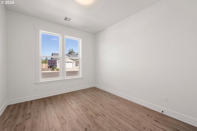 unfurnished room with hardwood / wood-style flooring