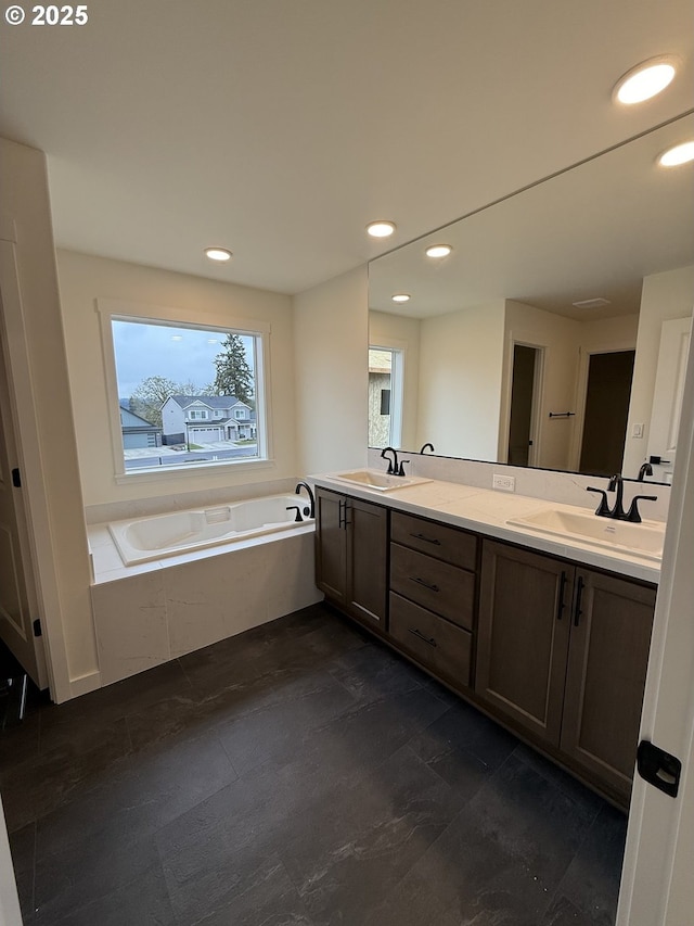 bathroom featuring tiled tub and vanity