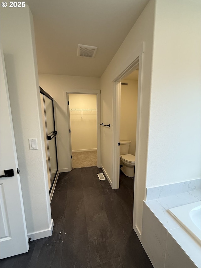 bathroom featuring shower with separate bathtub, hardwood / wood-style flooring, and toilet