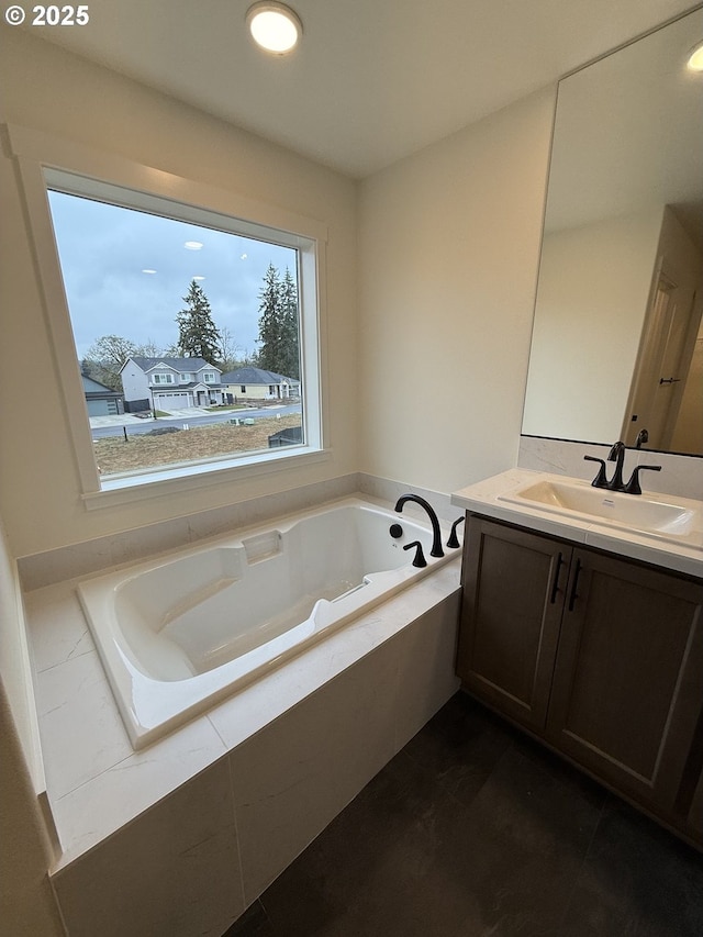 bathroom featuring vanity and tiled tub