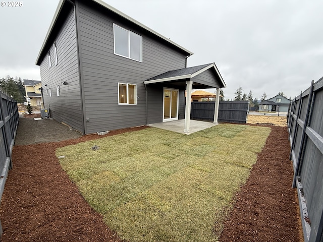 rear view of property featuring a patio, a lawn, and central air condition unit