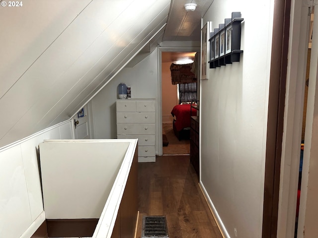 hallway featuring lofted ceiling and dark wood-style floors
