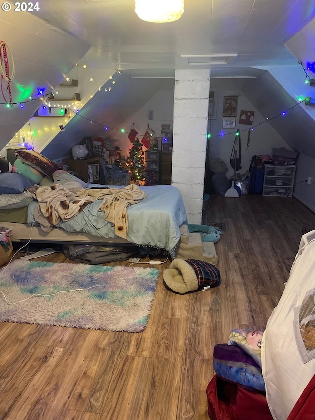 bedroom with hardwood / wood-style floors and vaulted ceiling