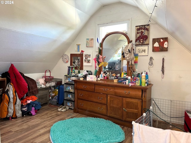 bedroom featuring wood finished floors and lofted ceiling