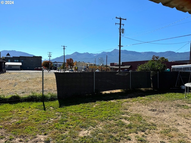 view of yard featuring fence and a mountain view