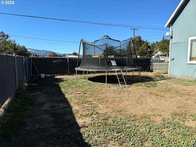 fenced backyard featuring a trampoline