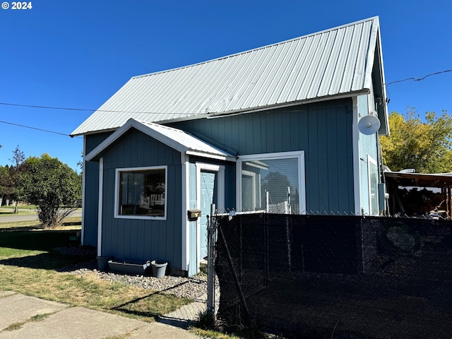 view of home's exterior with metal roof and an outdoor structure