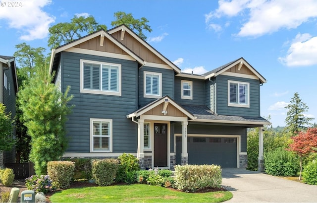 craftsman inspired home with a garage and a front lawn