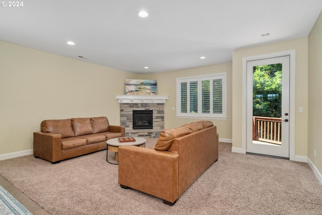 living room with light carpet and a stone fireplace