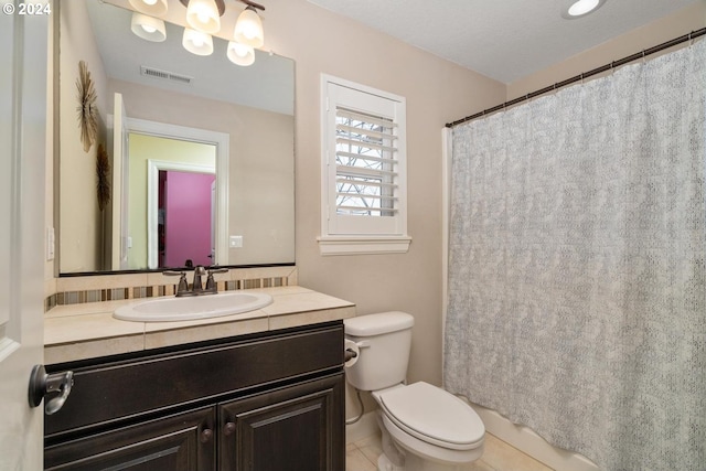 bathroom featuring toilet, tile patterned flooring, vanity, a textured ceiling, and walk in shower