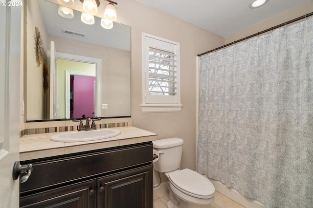 full bathroom with tile patterned floors, curtained shower, vanity, and toilet