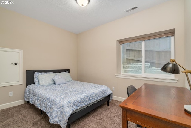 bedroom with a textured ceiling and carpet flooring