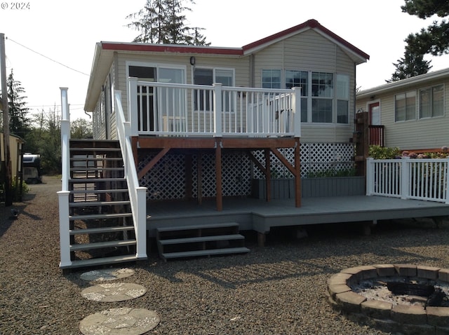 back of house featuring a fire pit and a deck