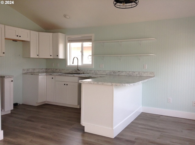 kitchen featuring dark wood-type flooring, white cabinets, lofted ceiling, and sink