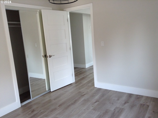 unfurnished bedroom featuring light hardwood / wood-style flooring and a closet