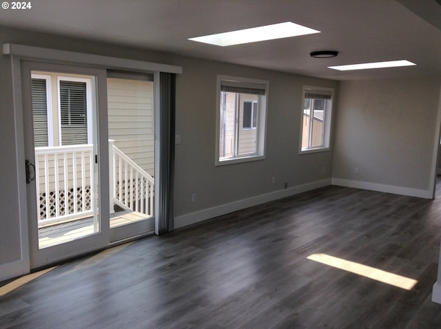 spare room with dark hardwood / wood-style flooring and a skylight