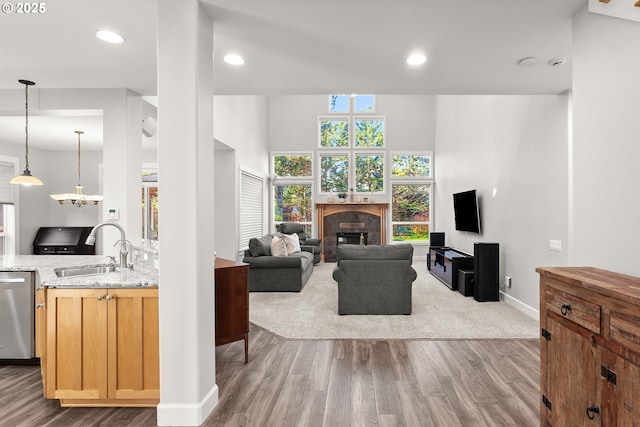 living room featuring wood-type flooring, sink, and a tile fireplace