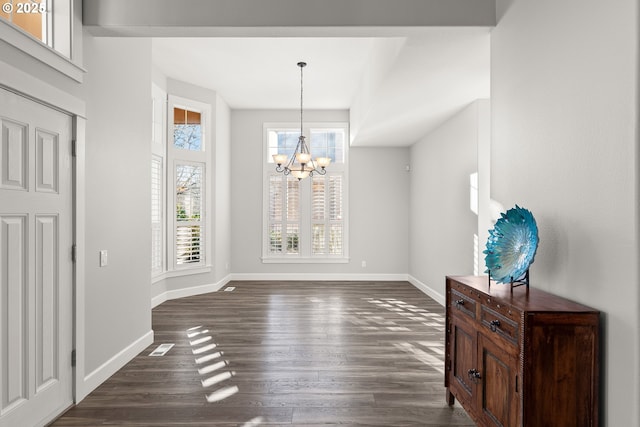 dining room with dark hardwood / wood-style flooring and an inviting chandelier