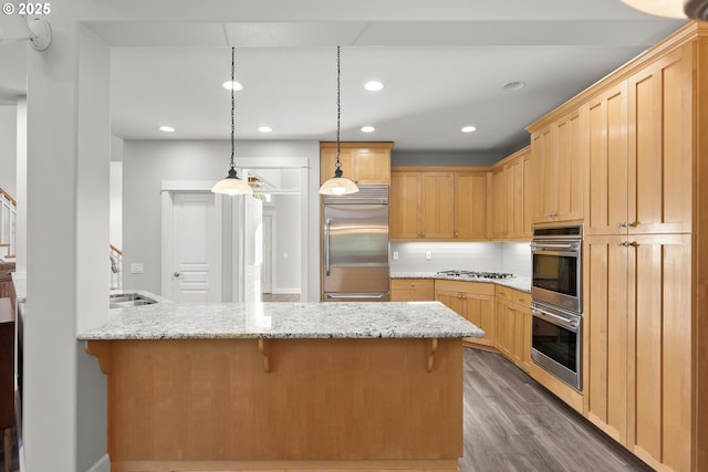 kitchen featuring backsplash, a kitchen breakfast bar, hardwood / wood-style flooring, appliances with stainless steel finishes, and kitchen peninsula