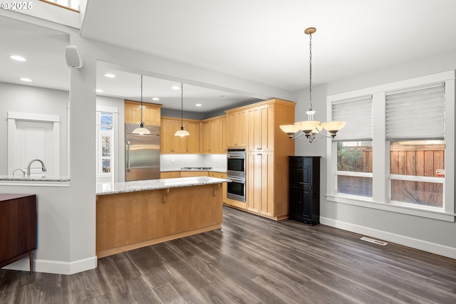 kitchen featuring dark wood-type flooring, built in fridge, double wall oven, hanging light fixtures, and a chandelier