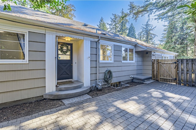 entrance to property featuring a gate, fence, and a patio