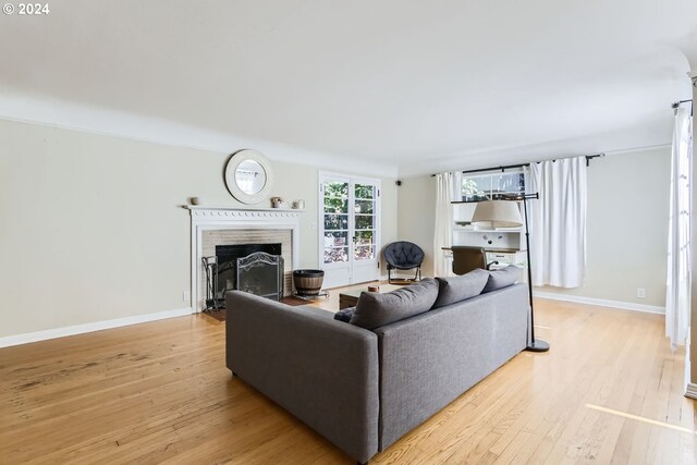 living room with light hardwood / wood-style floors and a brick fireplace