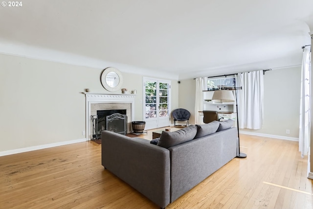 living room featuring light wood-style flooring, a fireplace, and baseboards