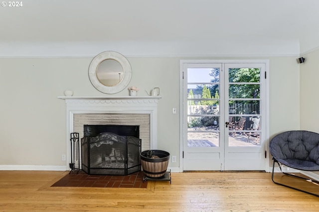 interior space featuring crown molding, hardwood / wood-style floors, and a brick fireplace