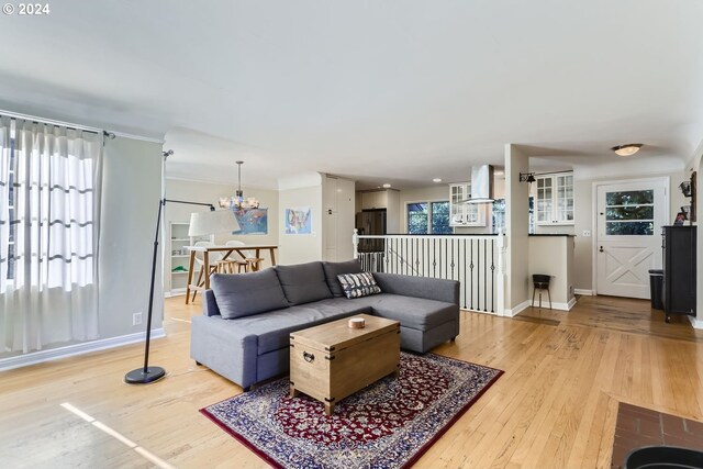 living room with ornamental molding, a chandelier, and wood-type flooring