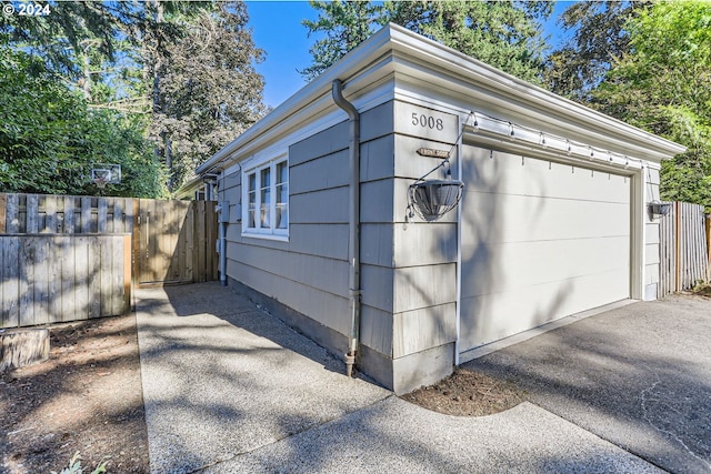 garage with driveway and fence