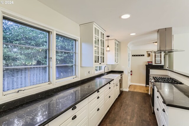 kitchen featuring dark hardwood / wood-style flooring, decorative light fixtures, white cabinets, and gas stove